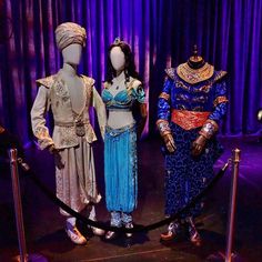 three mannequins dressed in costumes on display