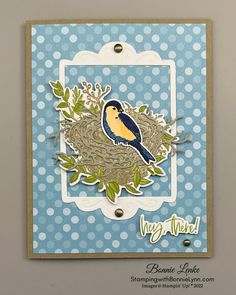 a blue card with a bird sitting on top of a nest in the middle of it