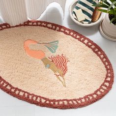 a round rug with an image of a woman on it next to a potted plant