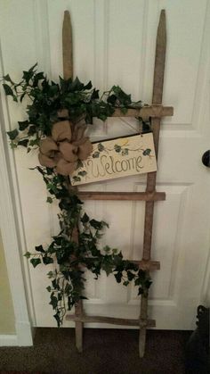 a welcome sign is hanging on the front door with greenery and ribbon around it