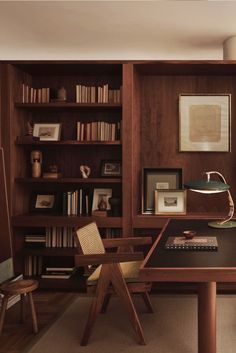 a wooden desk sitting in front of a book shelf filled with books