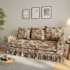 a living room scene with focus on the sofa and chair, coffee table and potted plant