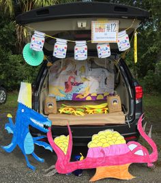 the trunk of a car is decorated with dragon decorations and paper plates for birthdays