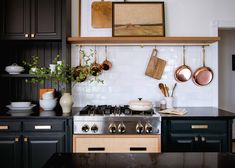 a stove top oven sitting inside of a kitchen next to black cabinets and counter tops