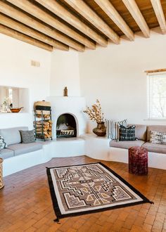 a living room filled with furniture and a fire place in the middle of a room