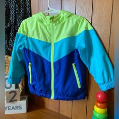 Neon Green And Blue Windbreaker Nwot. Size - 2t Boys Casual Green Outerwear For Playtime, Hooded Blue Outerwear For School, Multicolor Long Sleeve Outerwear For Playtime, Green Spring Outerwear For Playtime, Playful Green Outerwear For Spring, Blue Spring Outerwear For School, Spring Blue Outerwear For School, Multicolor Spring Outerwear For School, Blue Hooded Outerwear For Playtime