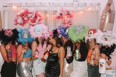 a group of women standing next to each other in front of a wall with decorations on it