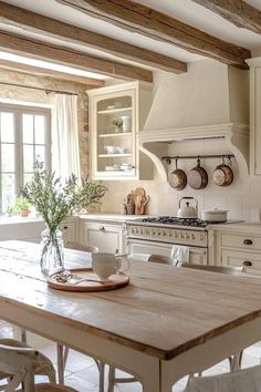 a kitchen with white cabinets and wooden table