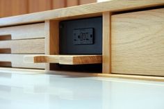 a close up of a wooden shelf with an electrical outlet in the center and two black outlets on each side