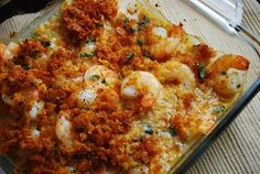 a casserole dish with shrimp and cheese on it, ready to be eaten