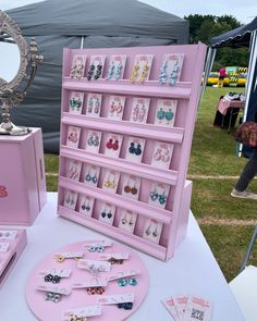 a pink display case sitting on top of a table next to a mirror and jewelry