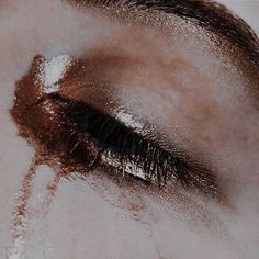 a woman's eye is covered in brown and white powdered eyeshade