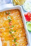 an enchilada dish with tortilla chips and salsa on the side