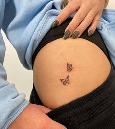 a pregnant woman's belly with two butterflies on her stomach and the lower part of her abdomen