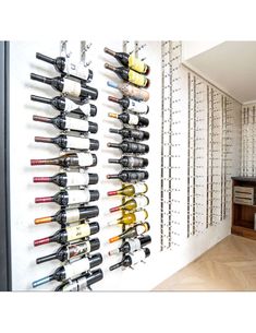 a wine rack filled with lots of bottles next to a wall mounted wine glass holder