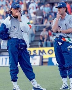 two baseball players standing next to each other on a field