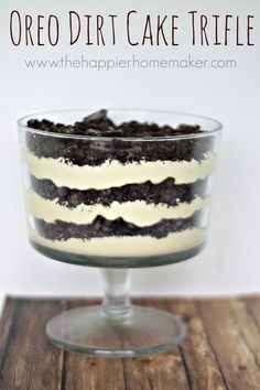 an oreo dirt cake trifle in a glass dish on top of a wooden table