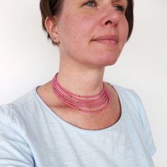 Beaded layered choker necklace multi stranded pink grey seed beads. Choker beaded with small glass beads in five strands, mostly pink seed beads with just a few grey ones spread out on the strands. All strands are of slightly different length, making the layers around the neck. Elegant beaded necklace for women in a minimalist style. Glass beads are about 2,5 mm. The necklace closes with a lobster clasp in a chain. Length (of shortest strand) is about 14 1/2 inches (37 cm), plus a lengthening chain of about 2 inches or 5 cm. This necklace is beaded only by hand. Only one necklace available in this color! For more layered choker necklaces please visit: https://etsy.me/2J1zRMC Or visit my shop: https://www.etsy.com/se-en/shop/tline/ Care information: Always remove jewelry before exercising, Pink Beaded Choker With Round Beads, Pink Tiny Beads Choker Necklace, Pink Choker With Round Tiny Beads, Pink Multi-strand Faceted Bead Necklace, Pink Multi-strand Beaded Necklace With Faceted Beads, Pink Multi-strand Faceted Beaded Necklace, Pink Multi-strand Beaded Necklace, Elegant Beaded Necklace, Beads Choker