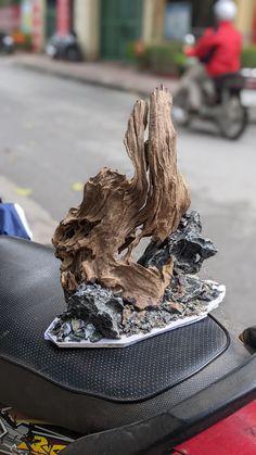 a scooter parked on the street with a piece of wood sticking out of it