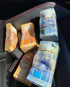 several stacks of money sitting in the back seat of a car