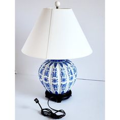 a blue and white lamp sitting on top of a table next to a charger