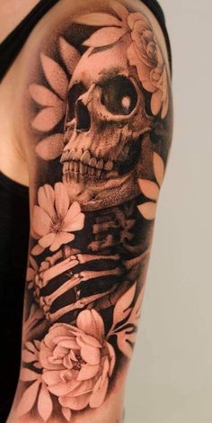 a woman's arm with a skull and flowers on it