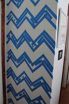 a white refrigerator covered in blue paint next to a wall