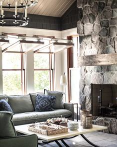 a living room filled with furniture and a fire place in front of a stone fireplace