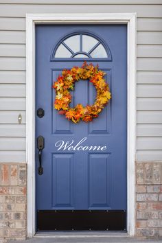 a blue front door with a wreath on it