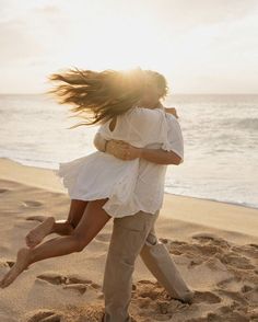 a man and woman are hugging on the beach