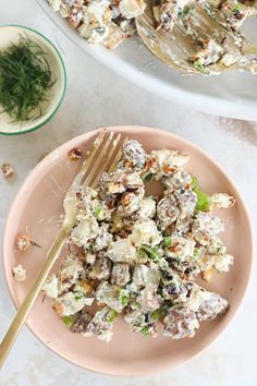 two plates with food on them next to a fork