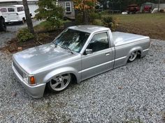 a silver pick up truck parked in gravel