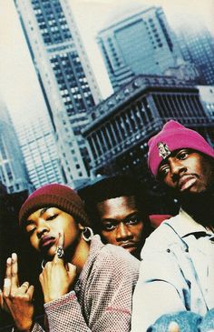 three young men standing next to each other in front of tall buildings and skyscrapers