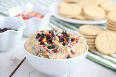 a bowl of ice cream with sprinkles and chocolate chips on the side