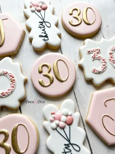 decorated cookies with pink and white frosting are arranged in the shape of numbers for 30th birthdays