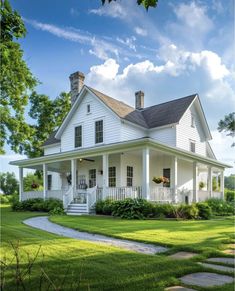 a white house sitting on top of a lush green field