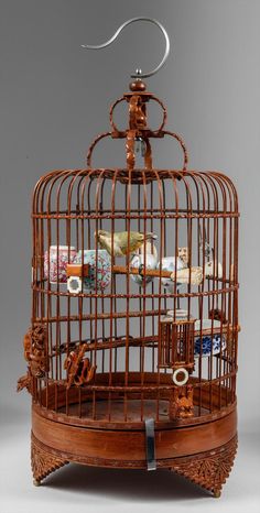 a birdcage filled with lots of stuff on top of a table