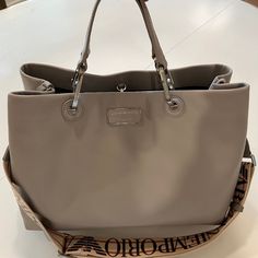 Authentic Emporio Armani Leather Tote Bag. Absolutely Beautiful Soft On Touch Italian Leather. Light Gray Soft Leather Exterior. Chrome Details. Navy Color Fabric Lining The Interior Of The Bag. Never Used - Like Brand New! It Has One Removable Zip Pocket Inside. Fits Over The Shoulder, Also Has Adjustable Shoulder Strap With Emporio Armani Logo. Armani Logo, 2024 Style, Color Fabric, Fall 2024, Navy Color, Leather Tote Bag, Womens Tote Bags, Italian Leather, Emporio Armani