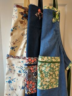 four different types of aprons hanging on a door