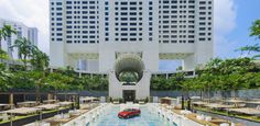 an outdoor swimming pool surrounded by palm trees