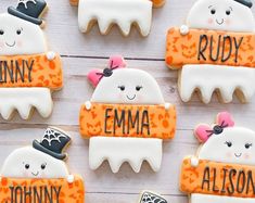 decorated cookies with name tags on them sitting on a white table top next to each other