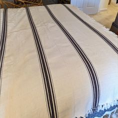 a bed covered in a white and black striped blanket