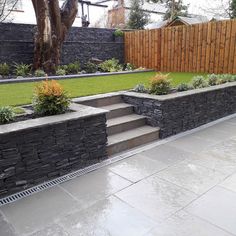 an outdoor garden with stone steps and grass