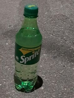 a bottle of sprite water sitting on the ground