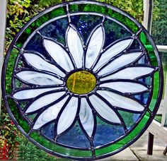 a stained glass window with a white flower in the center and green trim around it