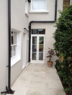 a white house with a potted plant on the front door and side walk way