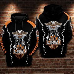 an orange and black harley davidson hoodie on a brick wall in front of a brick wall