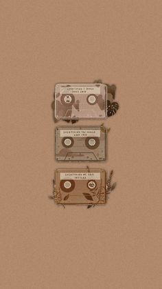 three cassettes are stacked on top of each other in front of a brown background