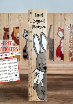 a wooden ruler with an image of a rabbit on it and the words loved beyond measure