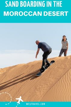 a man riding a skateboard down the side of a sandy hill next to a woman